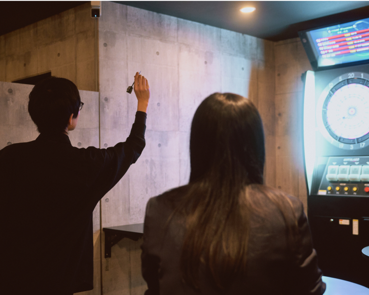 ギャラリーのヒーロ画像：ダーツをする男性と見守る女性の画像